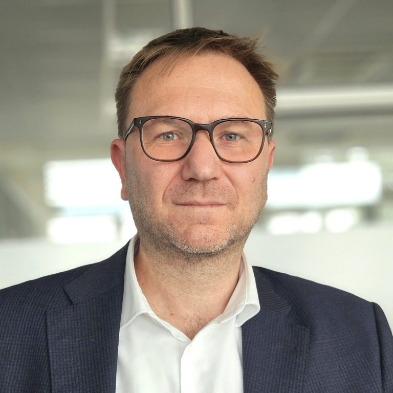 Dr. Daniel Schröder Mann mittleren Alters mit Brille und Anzug, freundlicher Gesichtsausdruck in hellem Büro.